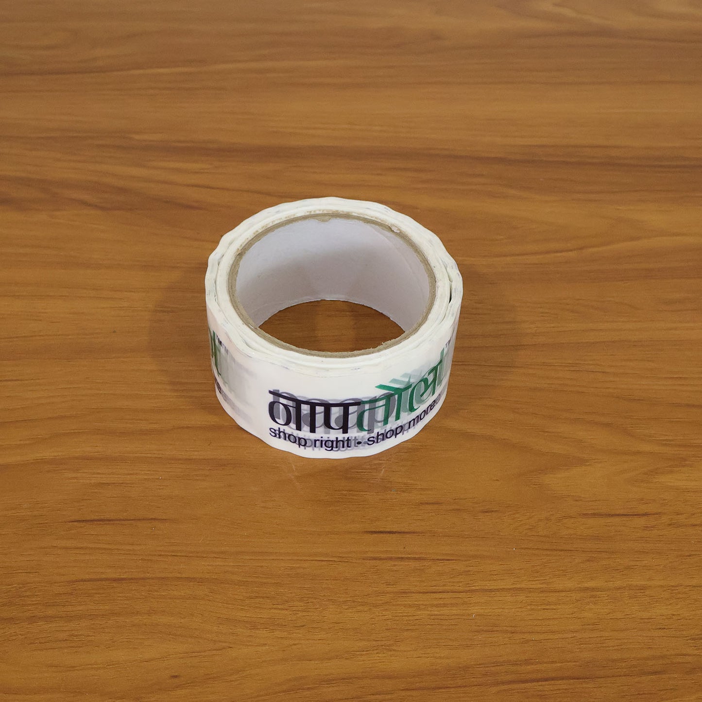 Wukusy Naaptol printed heavy-duty packaging tape 100x50mm on a roll, designed for secure parcel sealing and packaging.