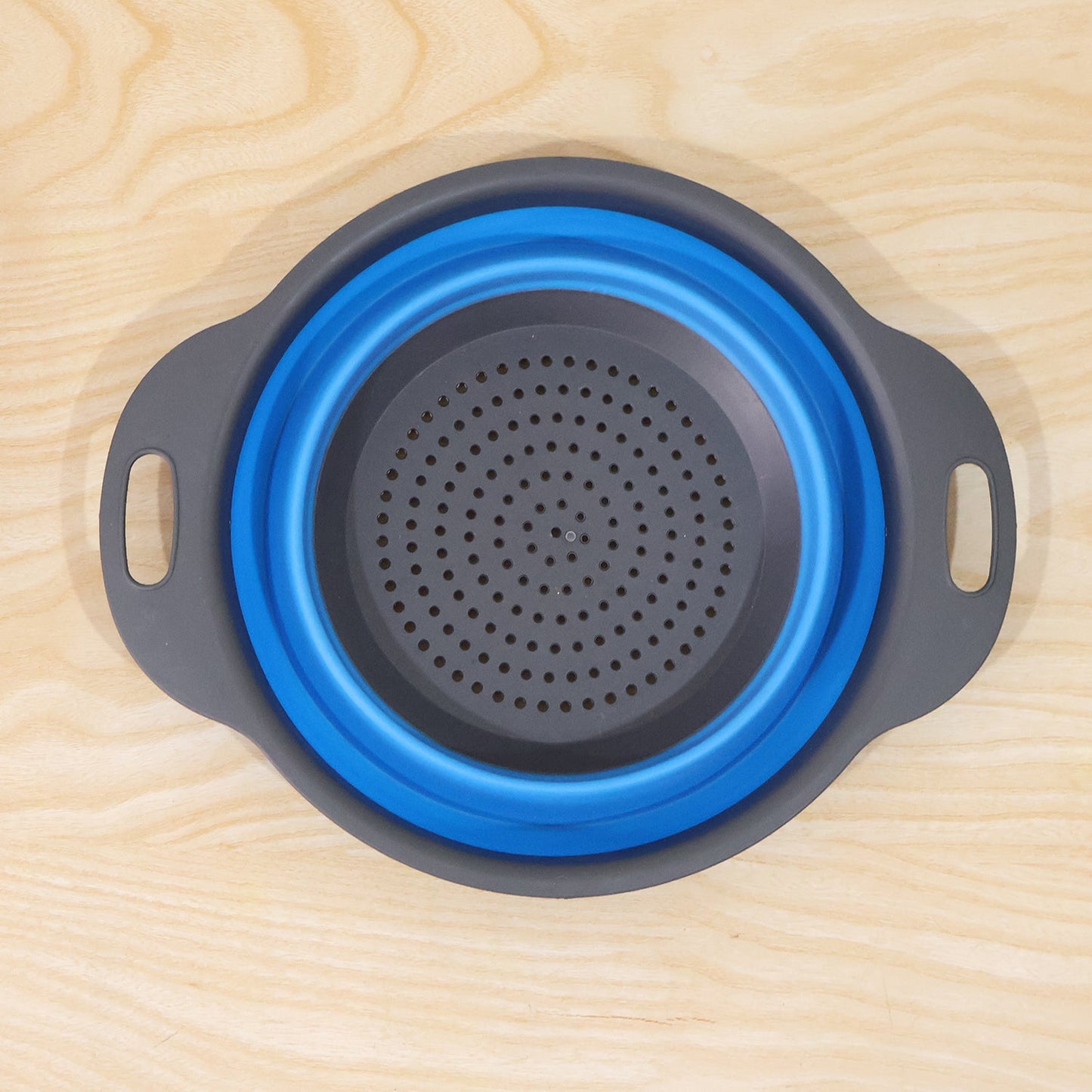 Wukusy silicone collapsible strainer in open position showing space-saving, easy-drain kitchen tool with ergonomic handle.