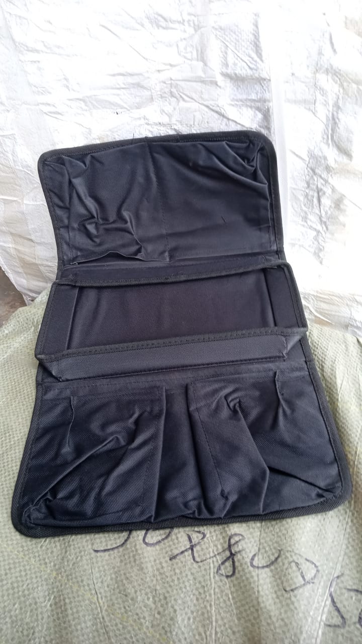 Black sofa arm rest hanging storage bag by Wukusy with multiple compartments for magazines, iPads, and books.