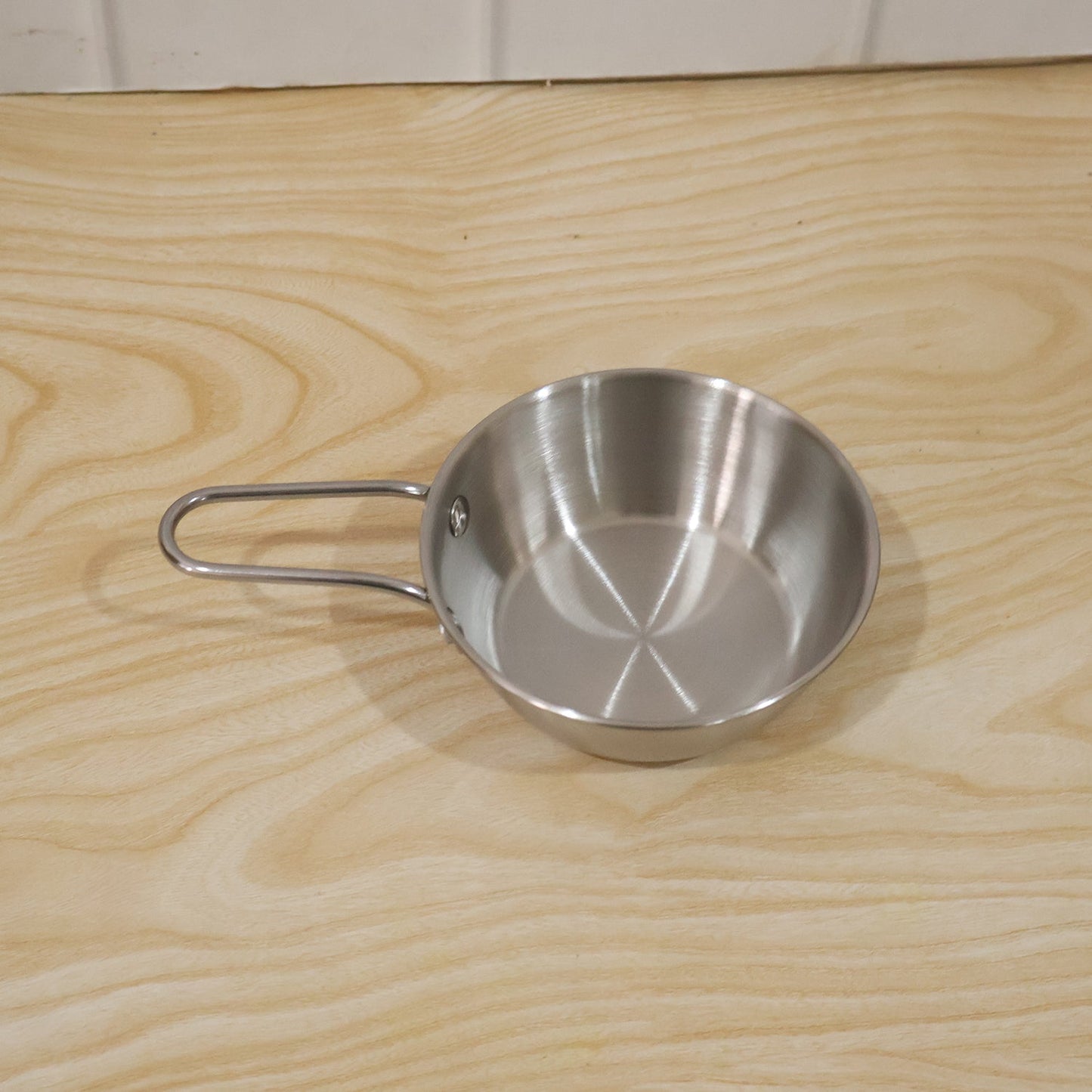 Wukusy stainless steel small tadka pan with long handle, 11 cm, used for tempering spices and cooking in the kitchen.