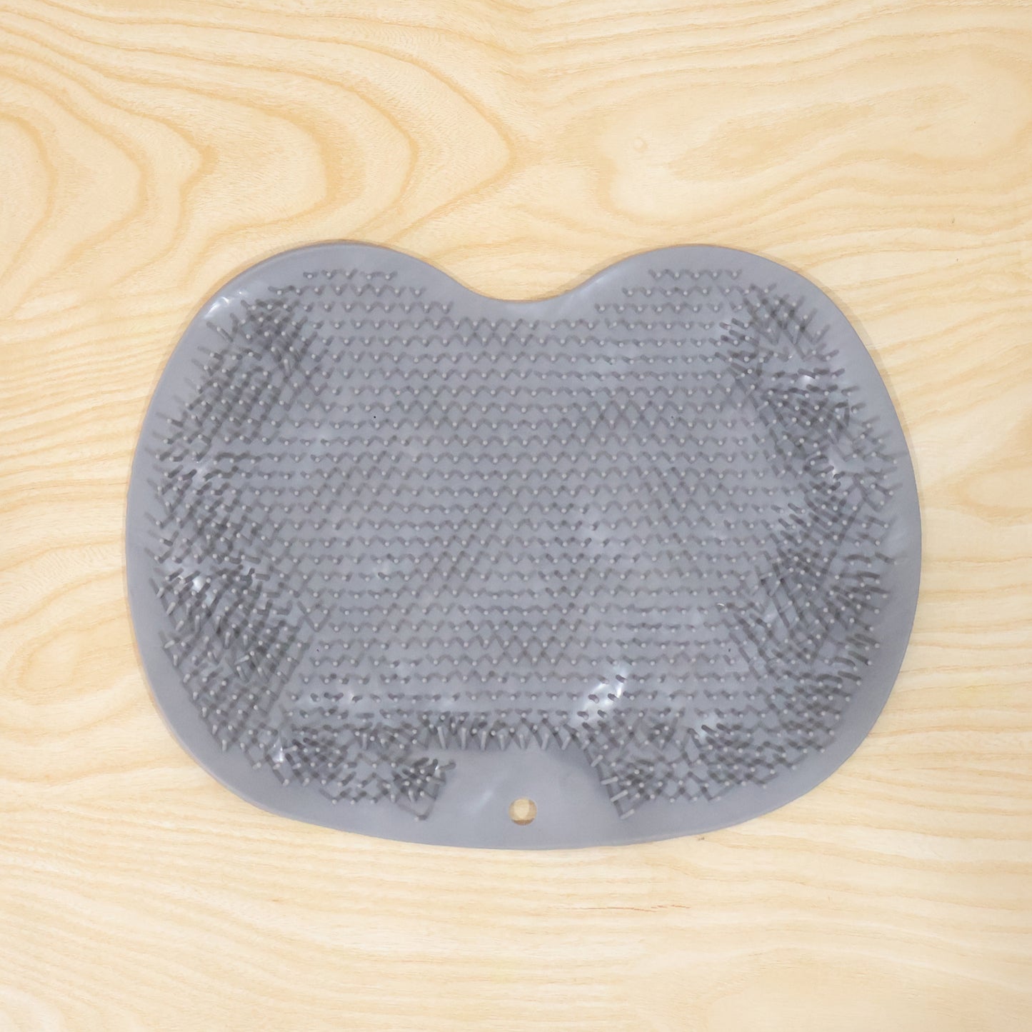 Wukusy silicone bathroom foot cleaning scrubber mat on a tiled floor, showing textured surface for foot scrubbing.