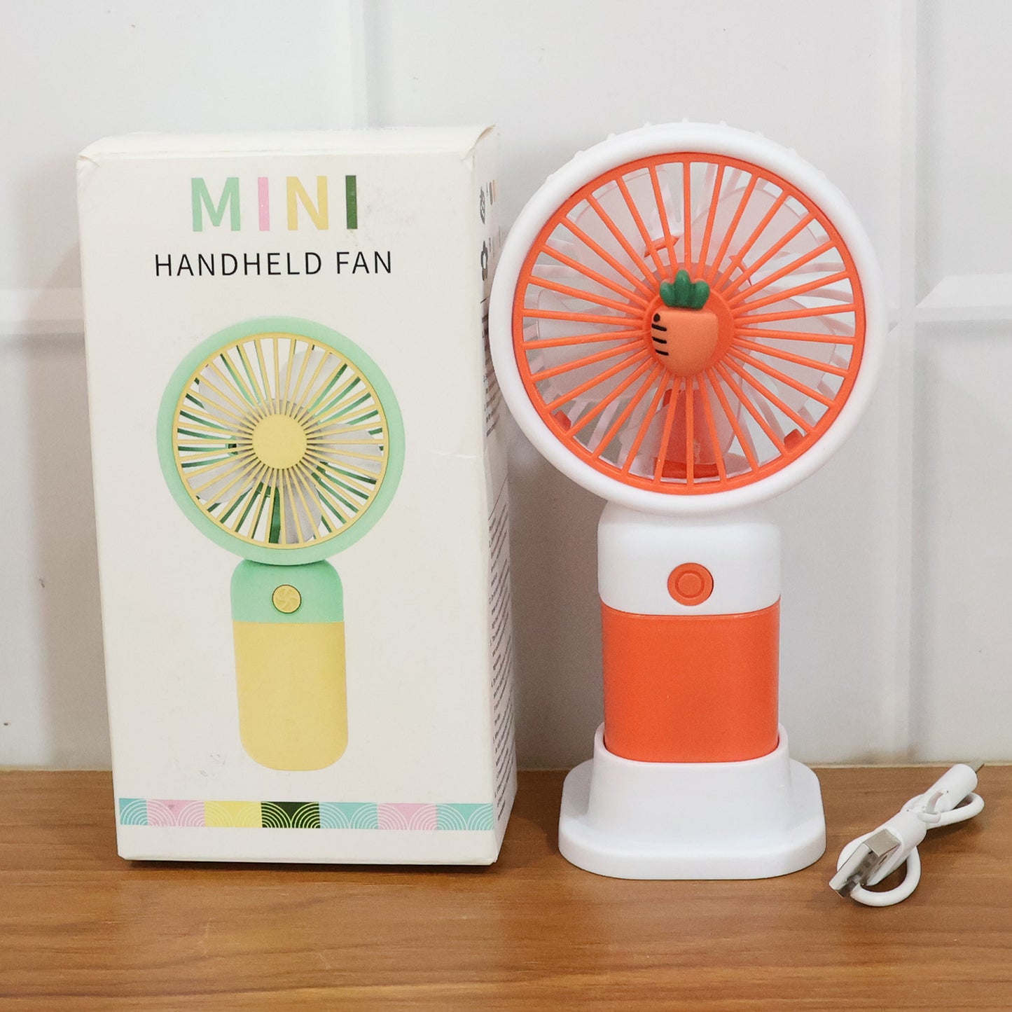 Wukusy rechargeable mini handheld fan with foldable design, compact size, and USB charging port for portable cooling.