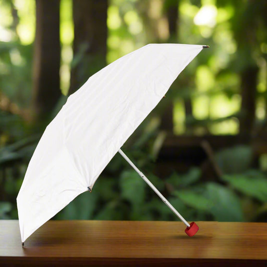 Wukusy 3-fold sun and rain protective solid foldable umbrella open outdoors, showing its compact design and sturdy frame.