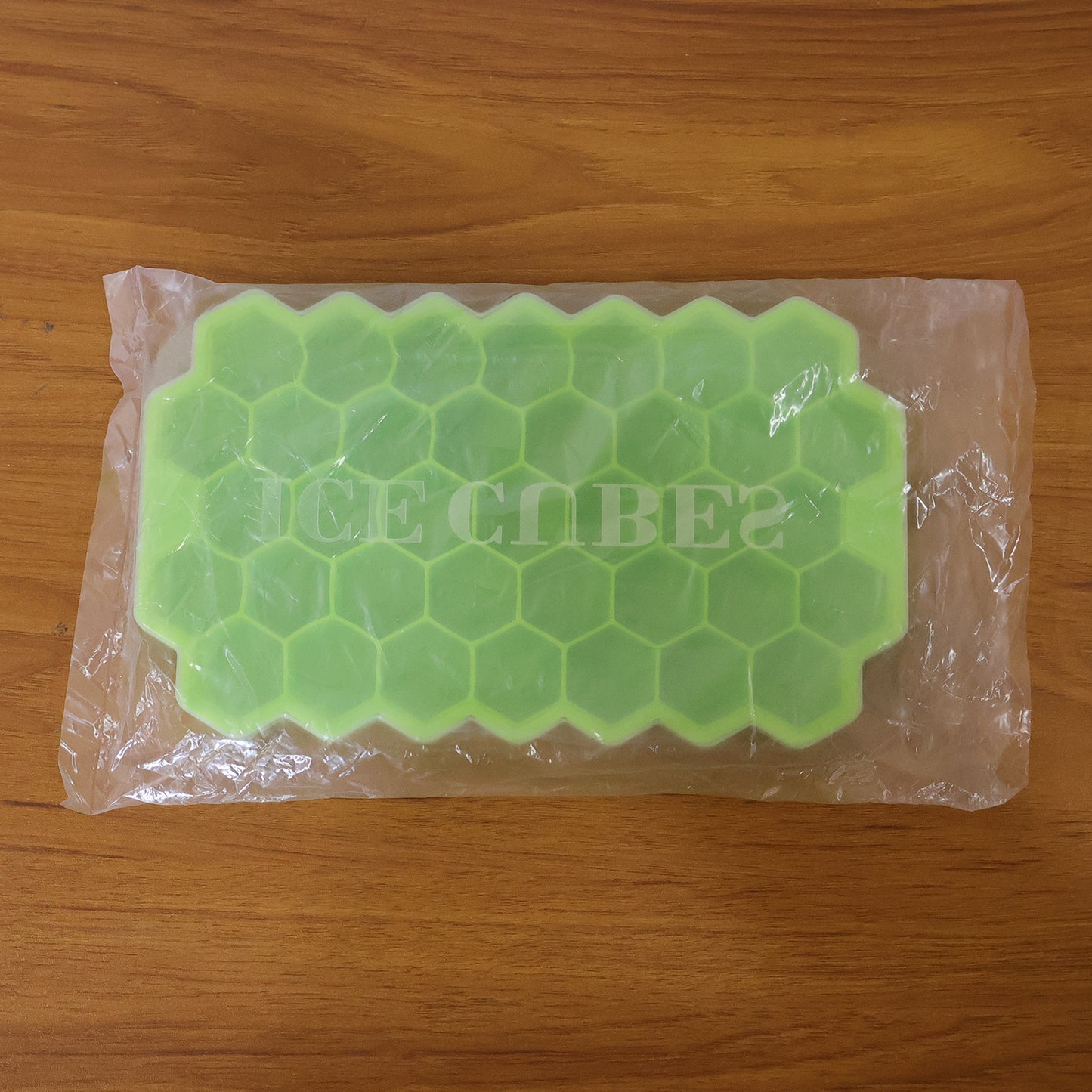 Wukusy premium honeycomb silicone ice cube tray with lid showing multiple ice cubes in a clear tray on a kitchen countertop