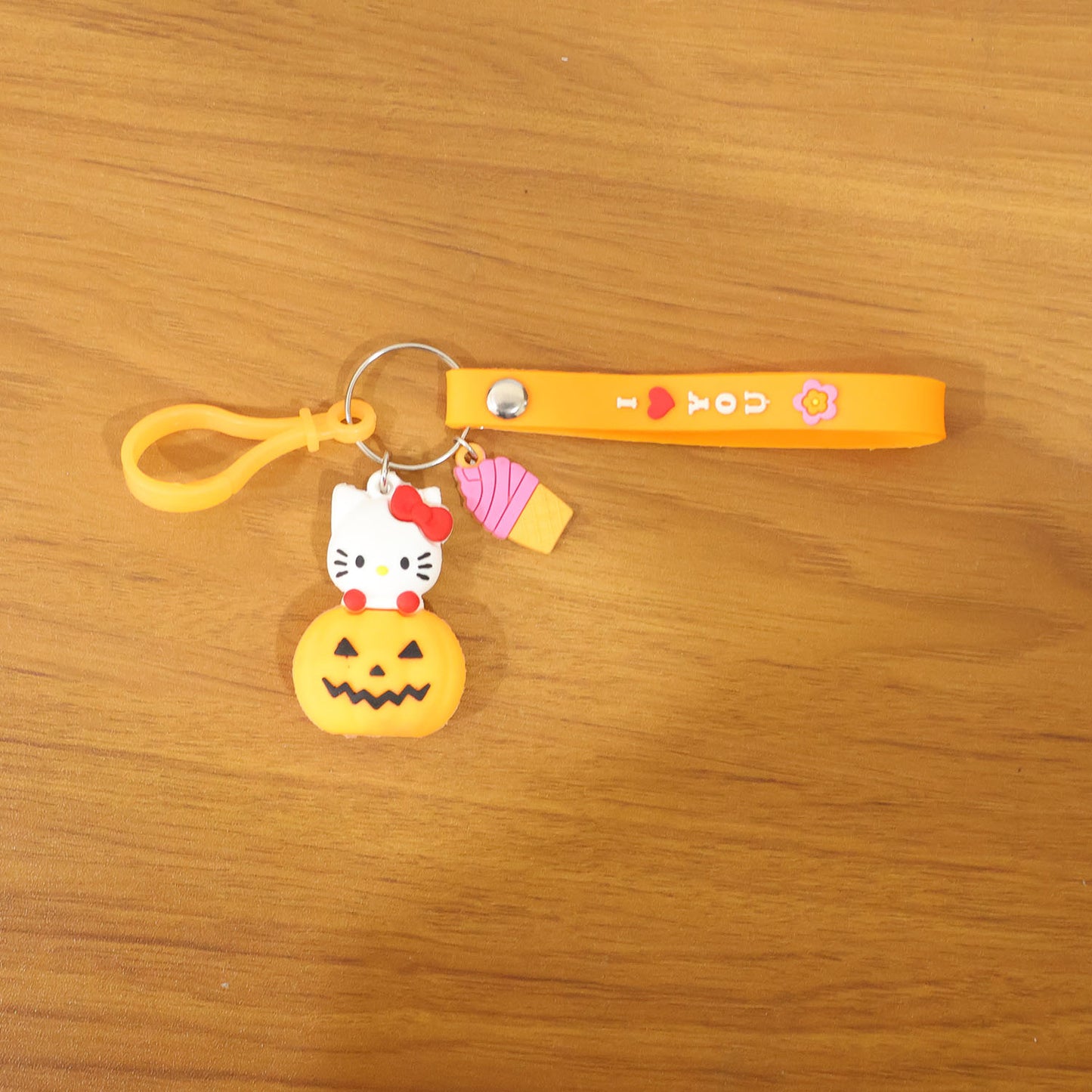 Cute cartoon kitty and pumpkin keychain by Wukusy, featuring a colorful, playful design on a small accessory.