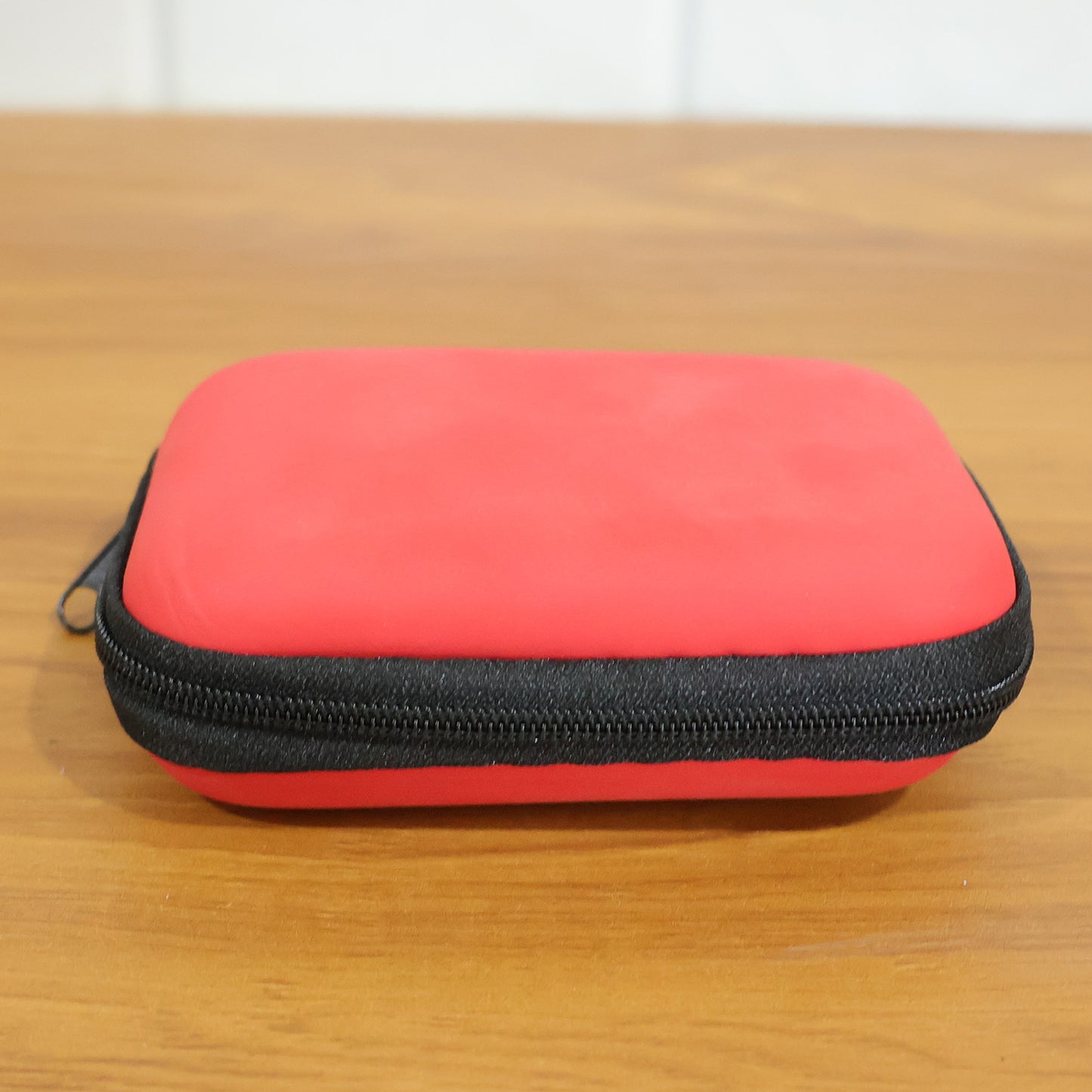 Wukusy premium wired earphones with zipper carry case, shown inside the open case with earphone cable and earbud tips visible.
