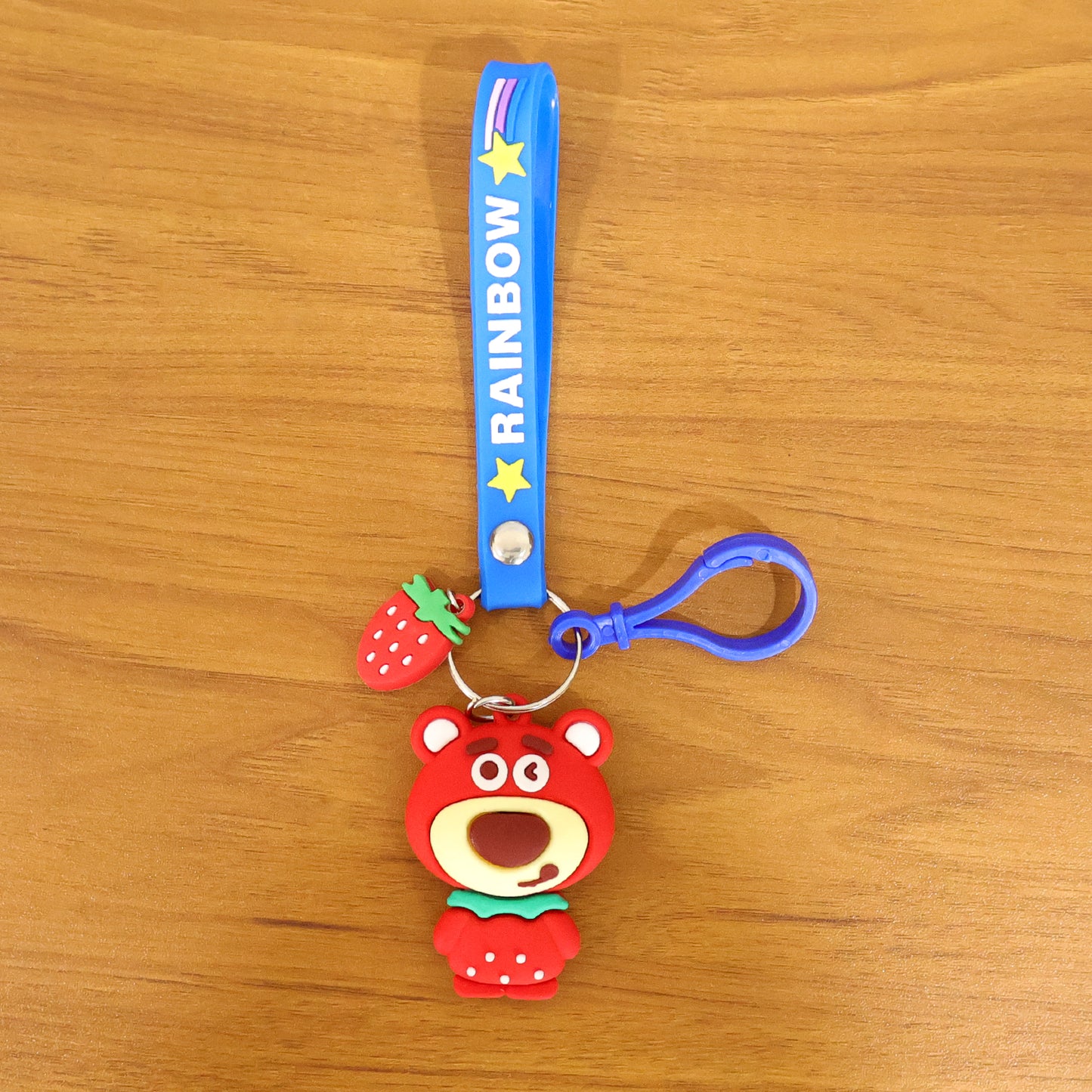 Cute teddy bear keychain with rainbow strap by Wukusy, featuring a soft plush bear attached to a colorful rainbow strap.