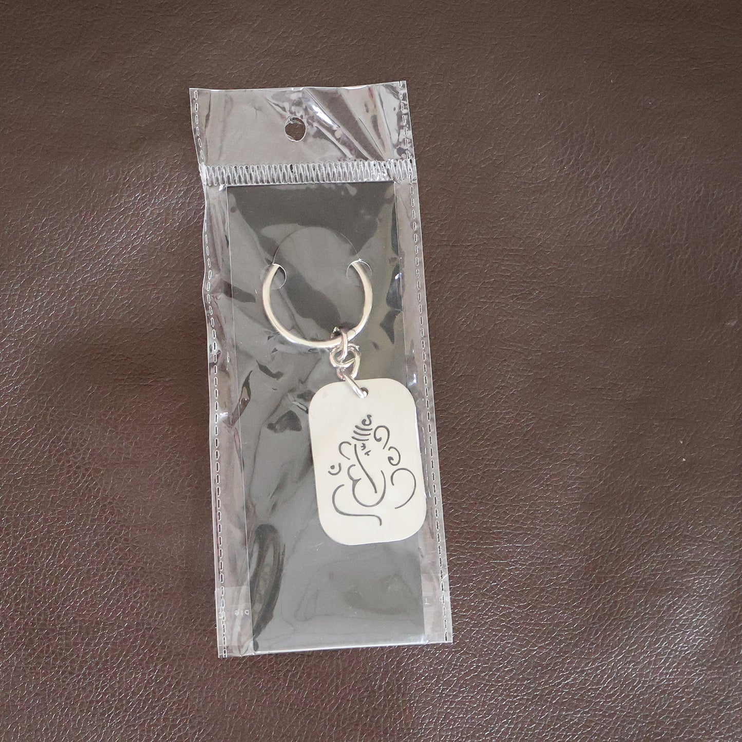 Metal Ganesh keychain with auspicious cut-out design by Wukusy, featuring detailed craftsmanship and keyring attachment.