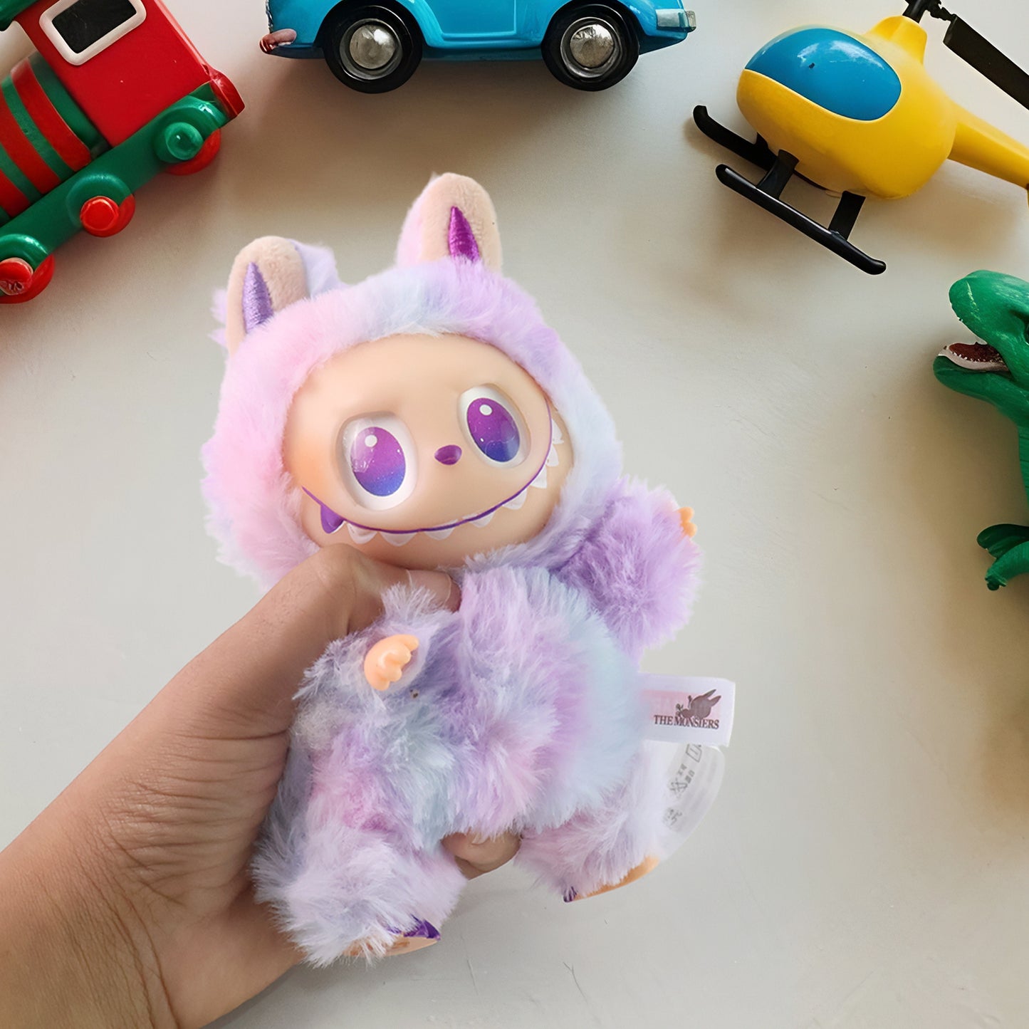 Light purple plush toy cartoon keychain with hook, colorful plush character from Wukusy, soft and adorable for keys or bags.