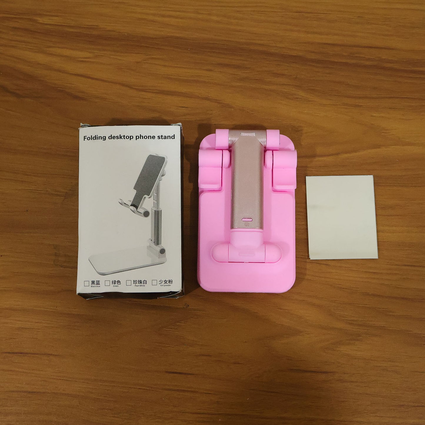 Adjustable Wukusy folding desktop mobile phone stand holder on a wooden surface, showing its compact, portable design.