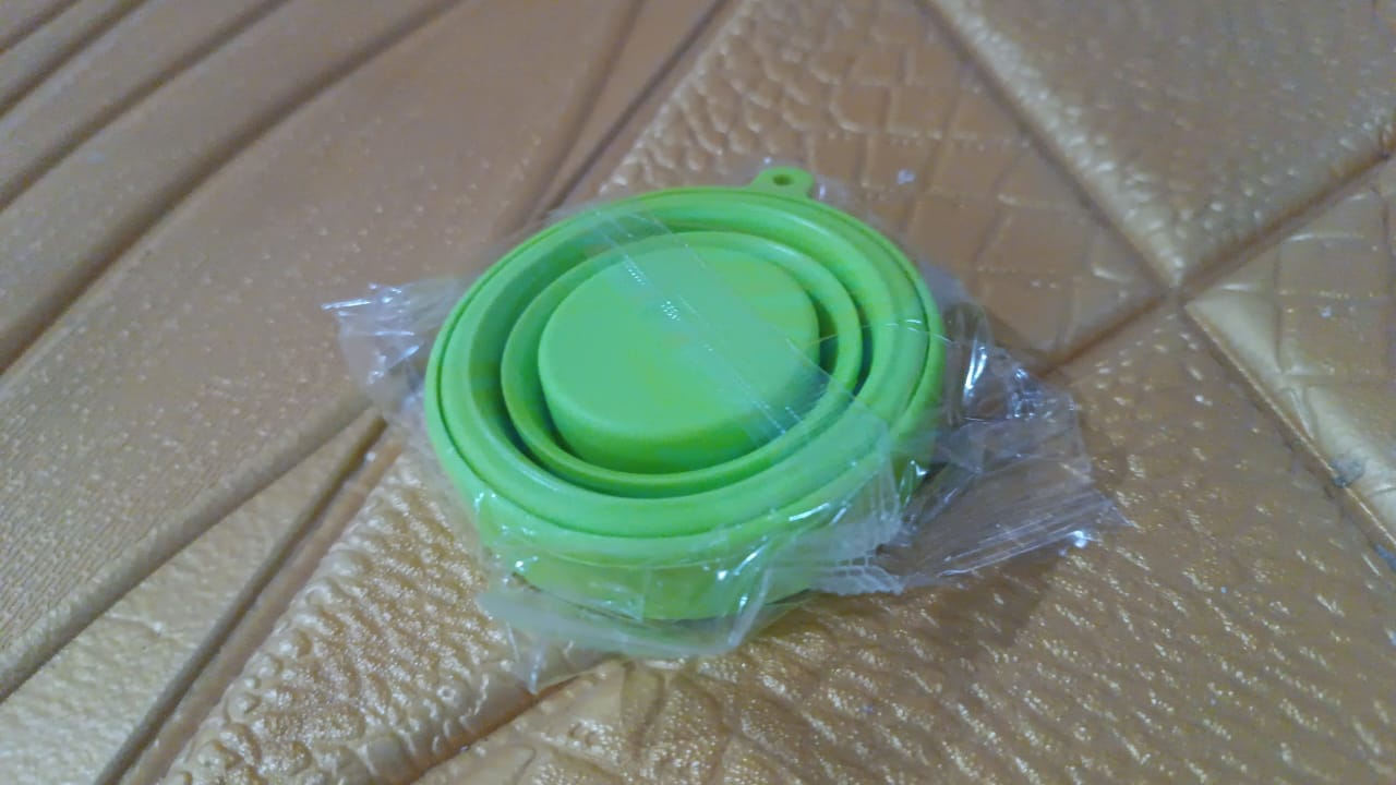 Round silicone foldable travel mug with lid by Wukusy, showing the compact, foldable design and transparent glass material.