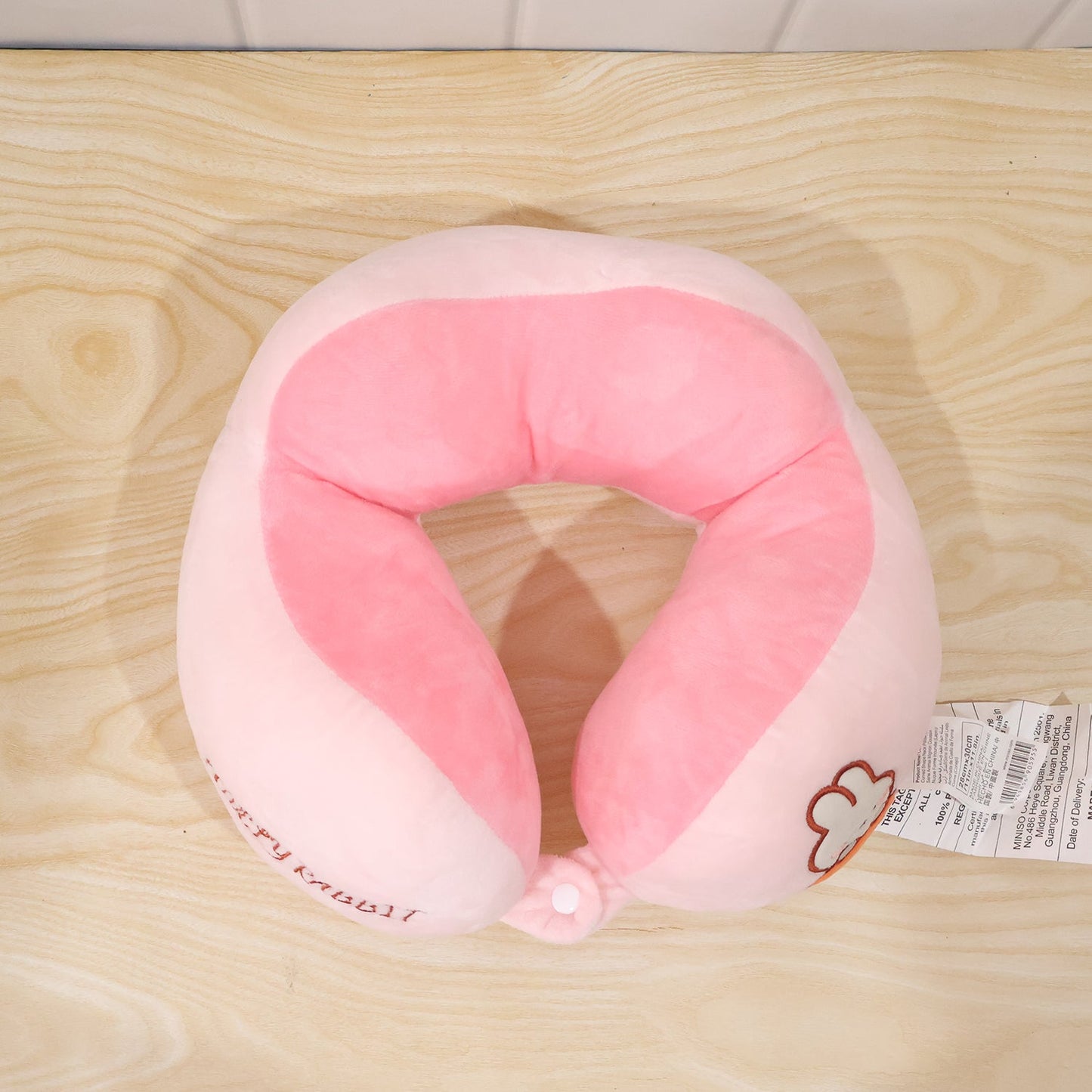 Soft plush pink and white U-shaped travel neck pillow by Wukusy, providing comfortable head and neck support for travel.