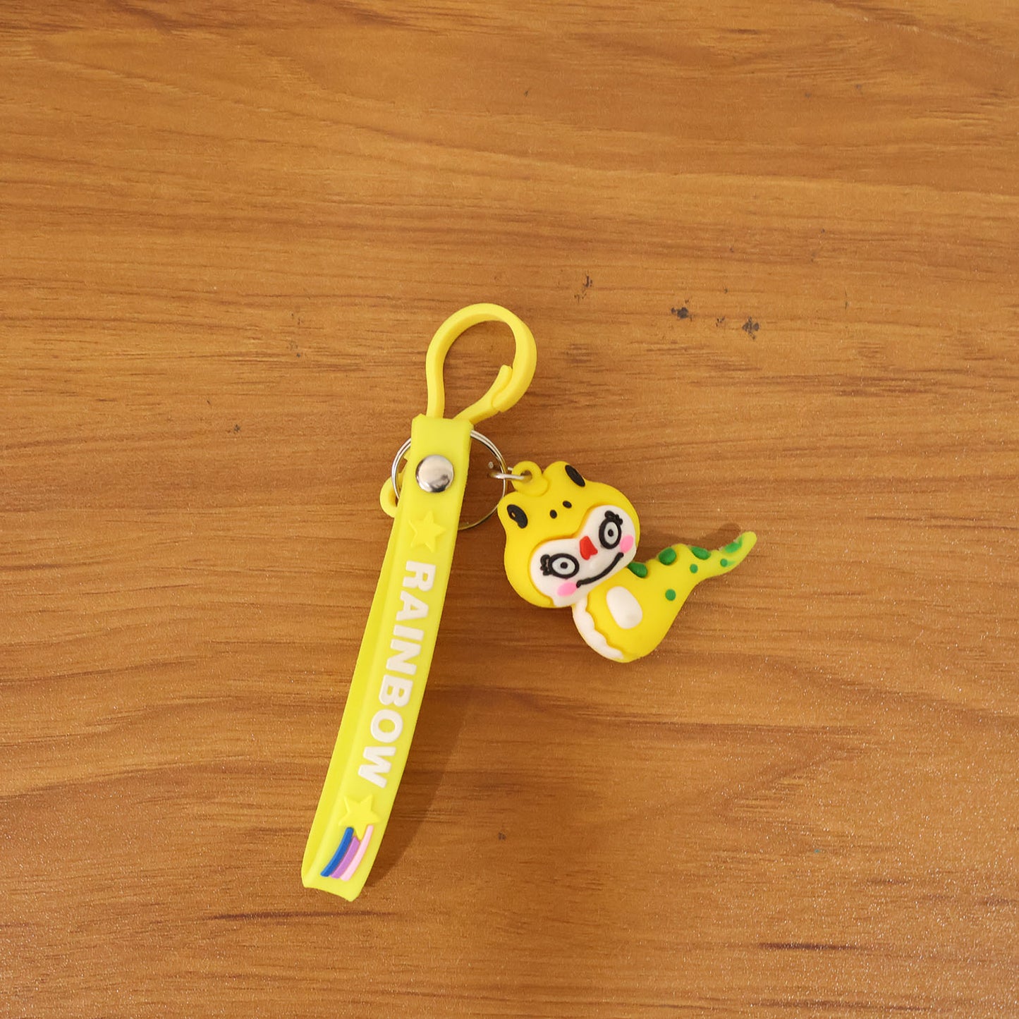 Cute cartoon dinosaur keychain by Wukusy featuring a colorful, smiling dinosaur design on a small metal keyring.