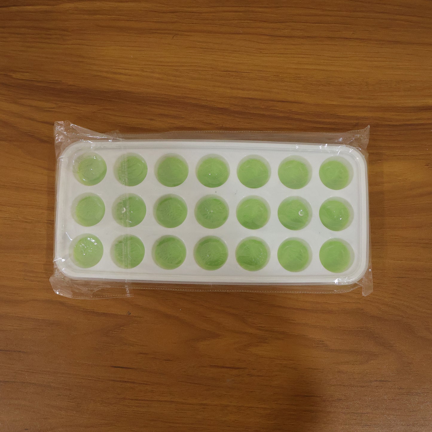 Wukusy 21-grid round plastic ice cube tray with lid, showing clear tray with round compartments filled with water.