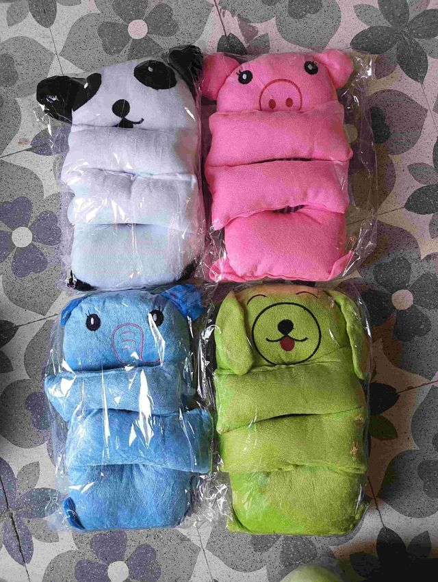 Baby shaping head support pillow in assorted colors, designed for infant comfort and proper head alignment.