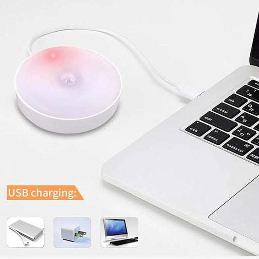 Wukusy rechargeable motion sensor LED night light with USB charging port, illuminating a dark room with soft white light.