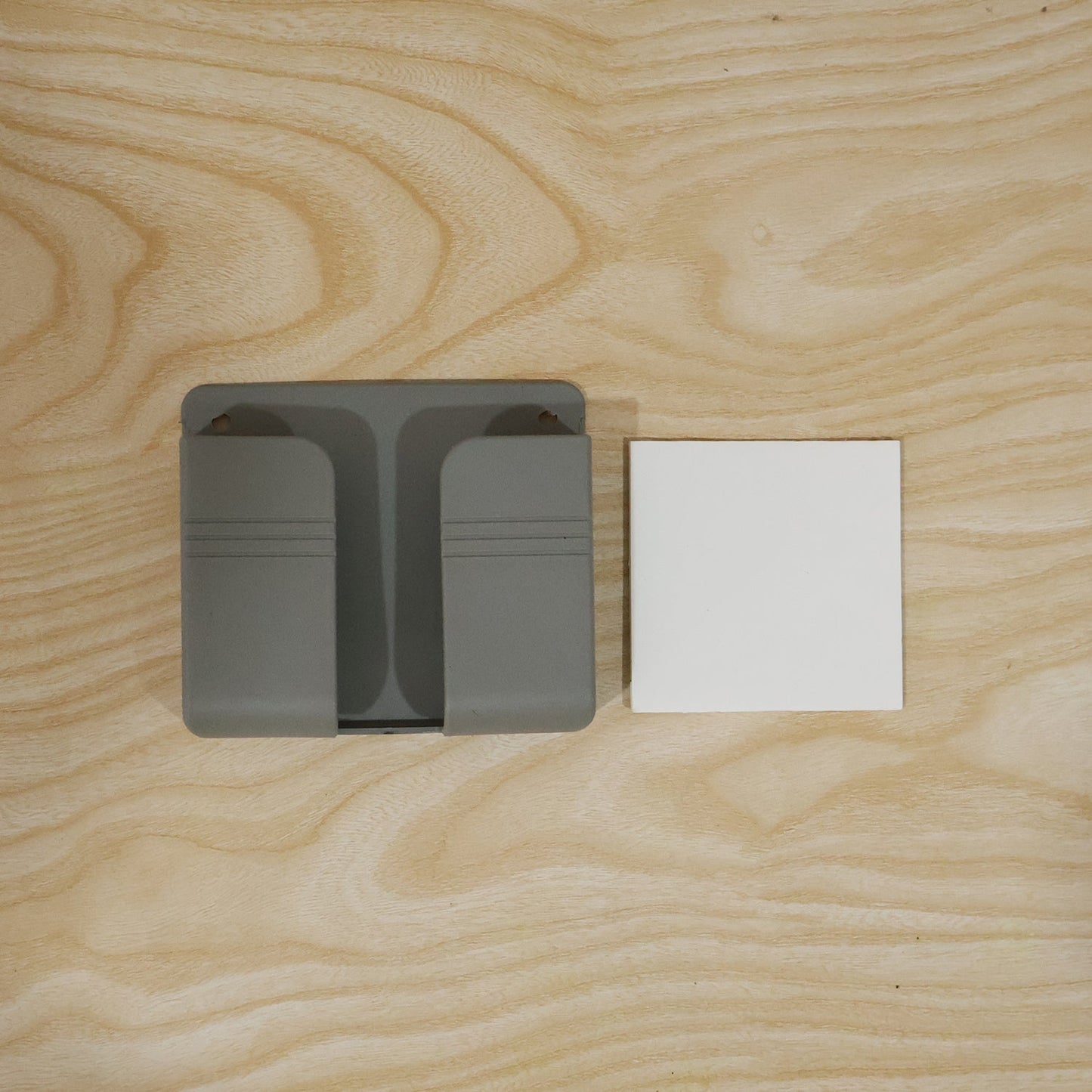 Wall-mounted Wukusy mobile remote holder with space-saving design, featuring multiple slots for organizing remote controls and small devices.