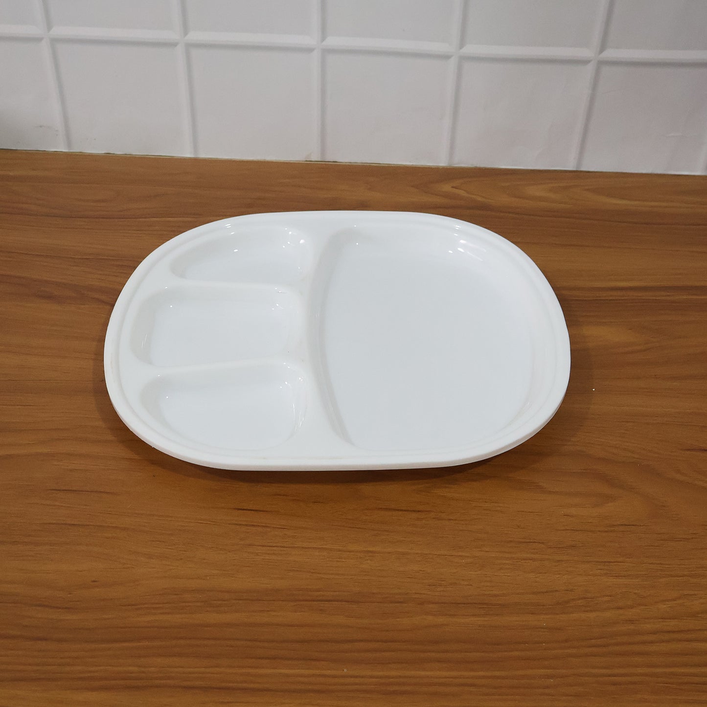Wukusy plastic large dinner plate with four-section compartment, ideal for serving diverse food in home and kitchen settings.