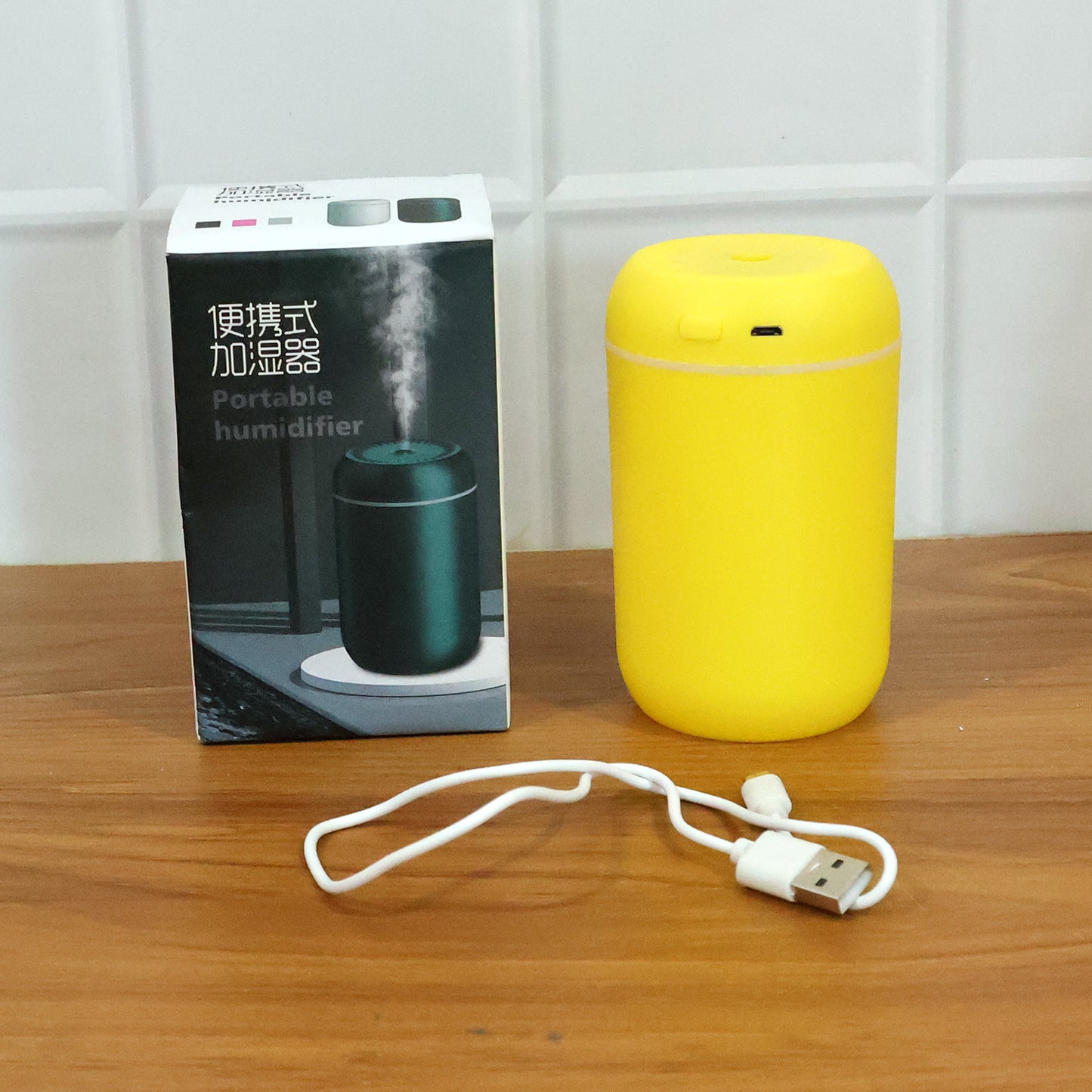 Wukusy portable USB-powered mini air humidifier emitting a fine mist, compact design ideal for desktop use.