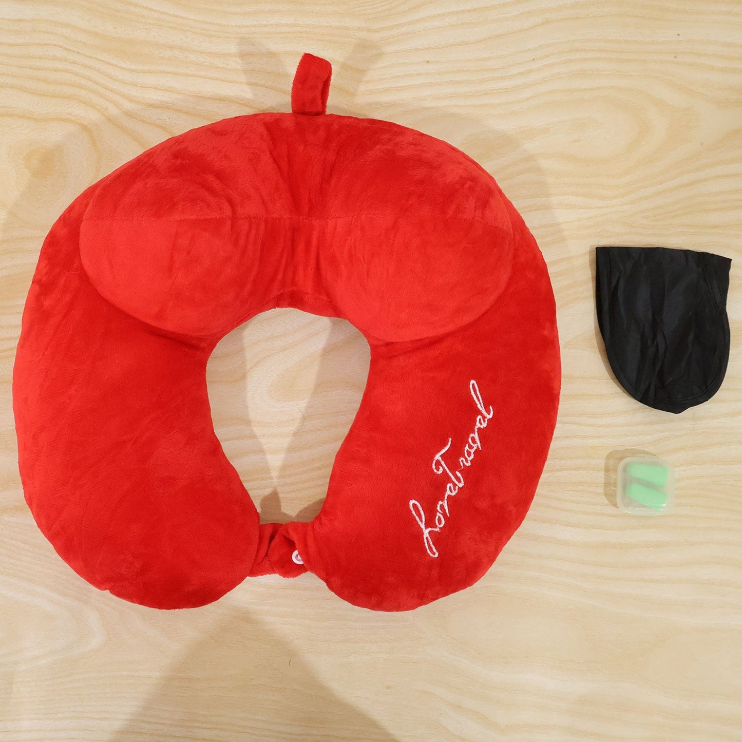 Wukusy 3-in-1 travel neck pillow with sleep eye mask and ear plugs, showing soft fabric pillow, eye mask, and ear plugs laid out.
