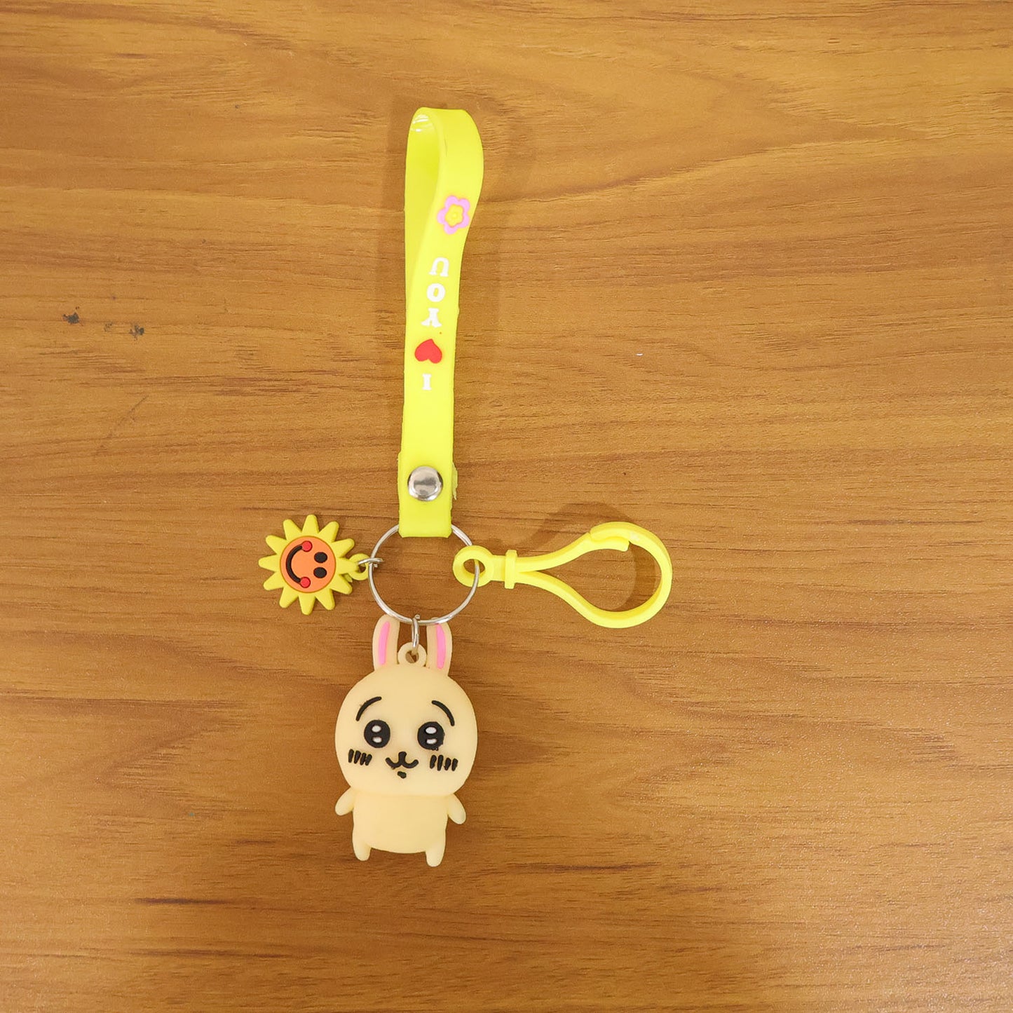 Cute cartoon bunny silicone keychain with decorative strap featuring Wukusy branding, displayed with vibrant colors and detailed design.