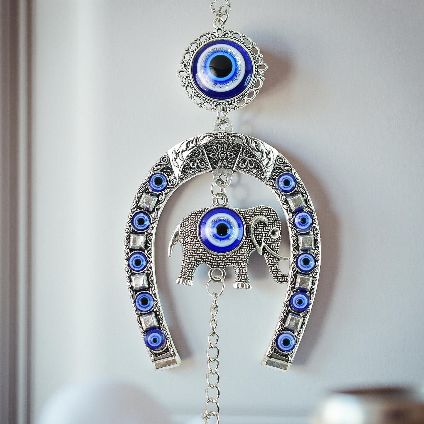 Decorative evil eye hanging wind chime with elephant and horseshoe motif, featuring colorful beads and metal accents, by Wukusy.