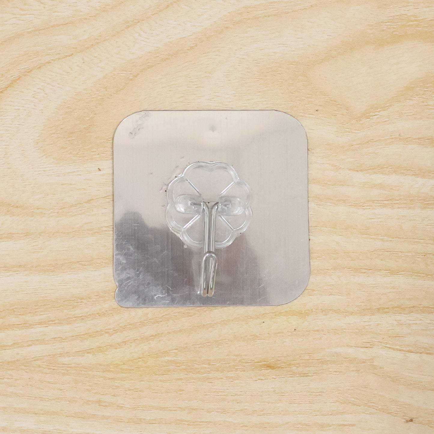 Transparent heavy-duty self-adhesive wall hook by Wukusy mounted on a wall for hanging items