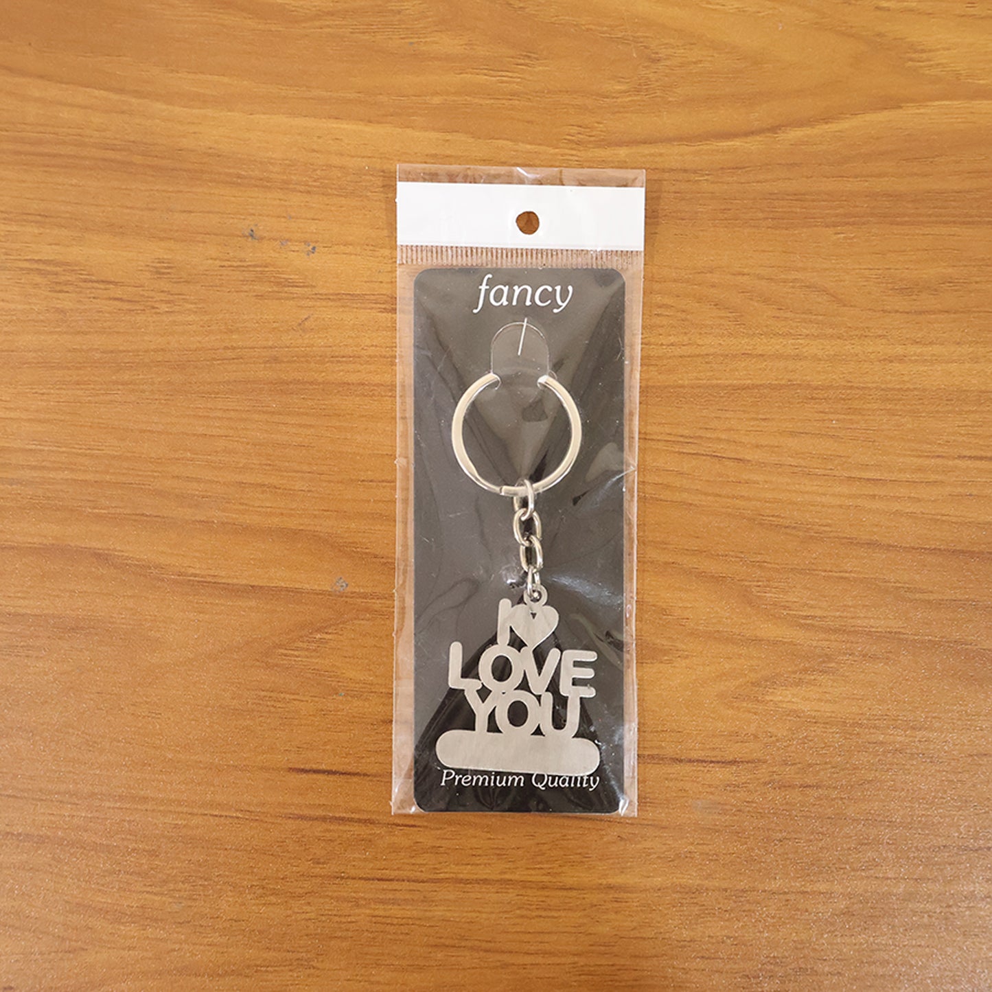 Wukusy premium metal "Love You" keychain with engraved design, hanging from a keyring, on a neutral background