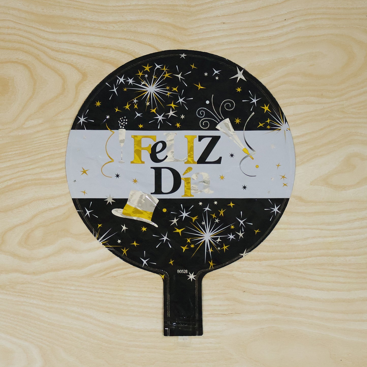 Black and gold Feliz Dia round foil balloon from Wukusy, featuring festive happy birthday design, inflated and ready for celebration.