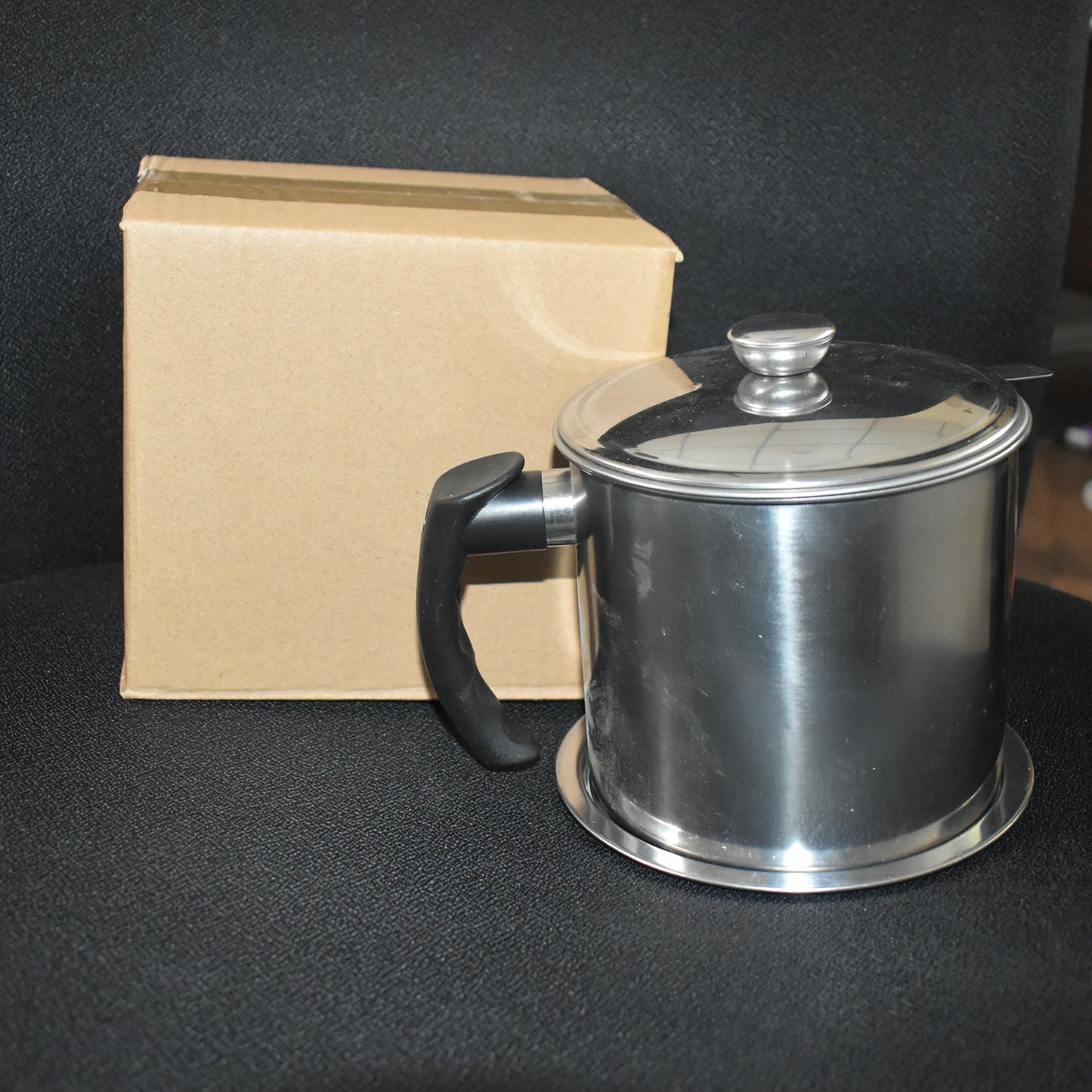 Stainless steel oil strainer pot with lid and filter mesh by Wukusy, shown with the lid open and filter mesh inside.