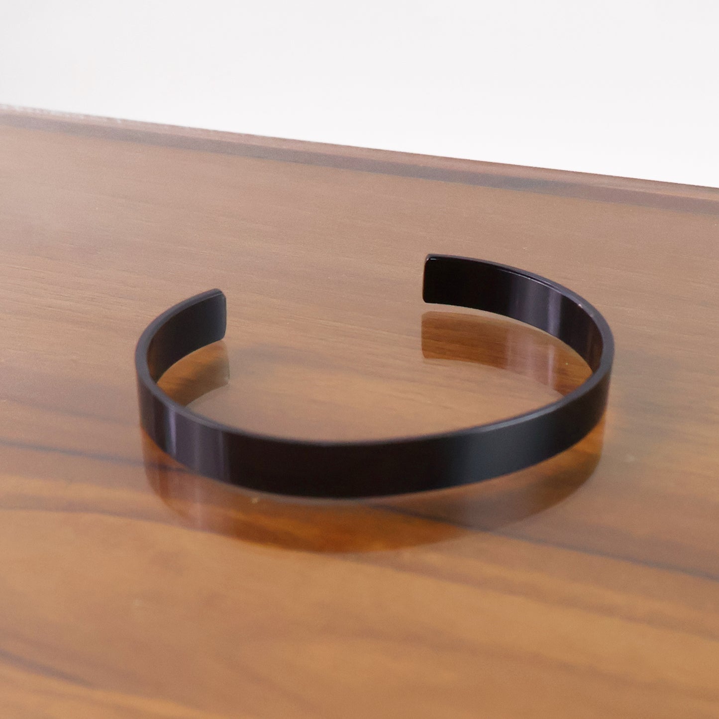 Elegant black-plated stainless steel kada bracelet by Wukusy, showcasing its sleek design and polished finish.