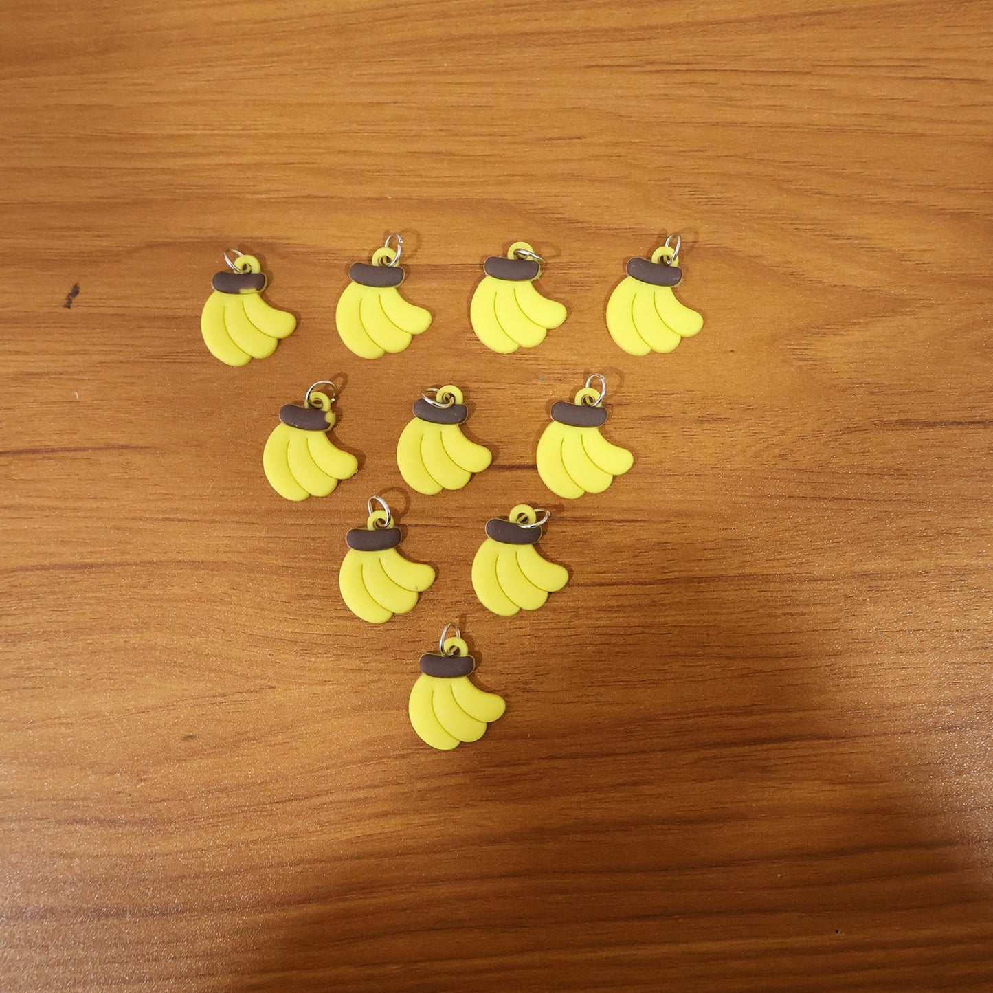 Set of 10 cute banana-shaped bag charm keychains by Wukusy, featuring bright yellow and playful design details.