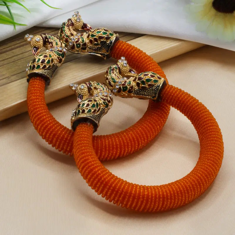 Traditional peacock design pearl bangles for women featuring intricate craftsmanship and elegant detailing in a stylish jewelry set.