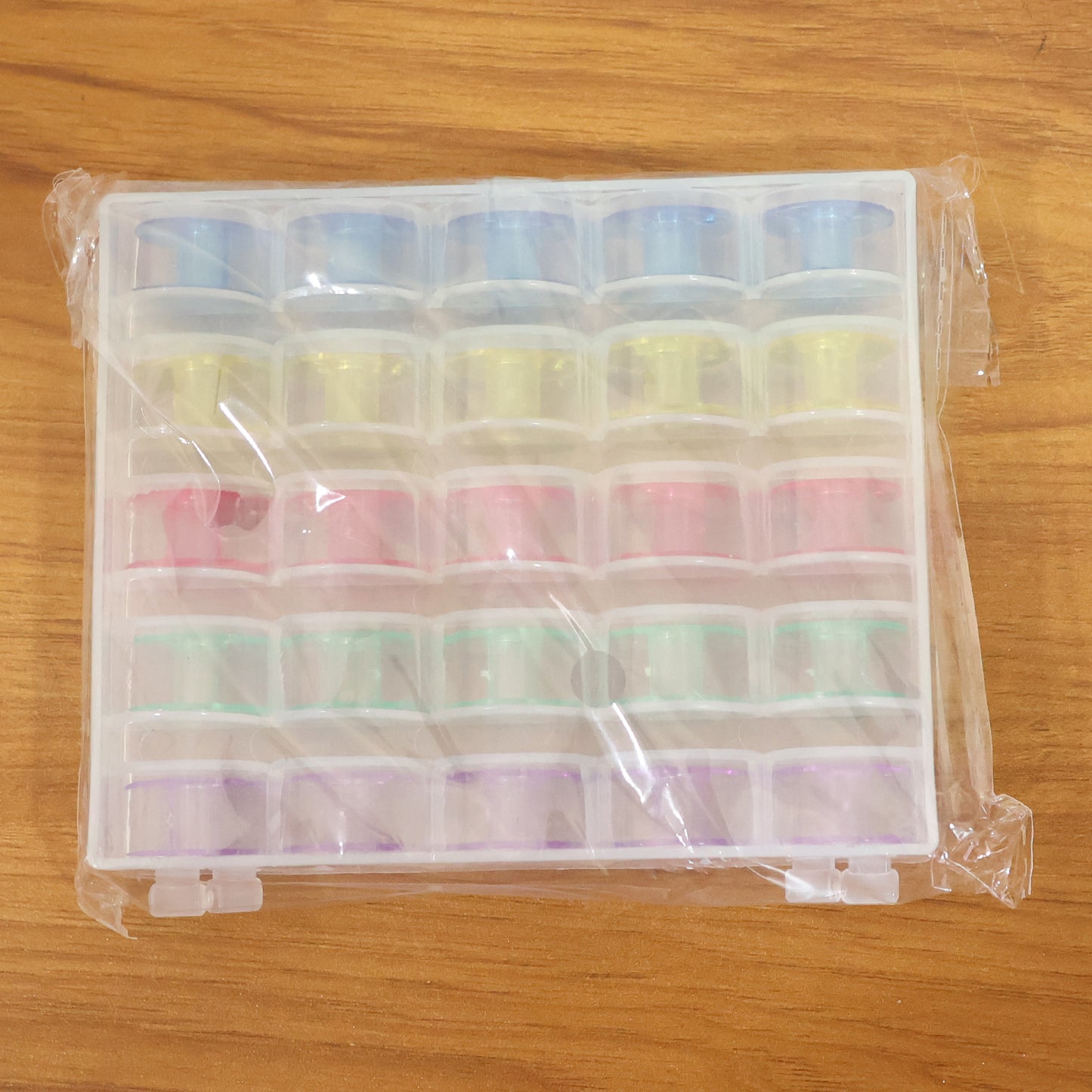 Wukusy Doris Roller Sewing Machine Bobbin Set with 25 plastic bobbins for sewing machine spools and thread management.