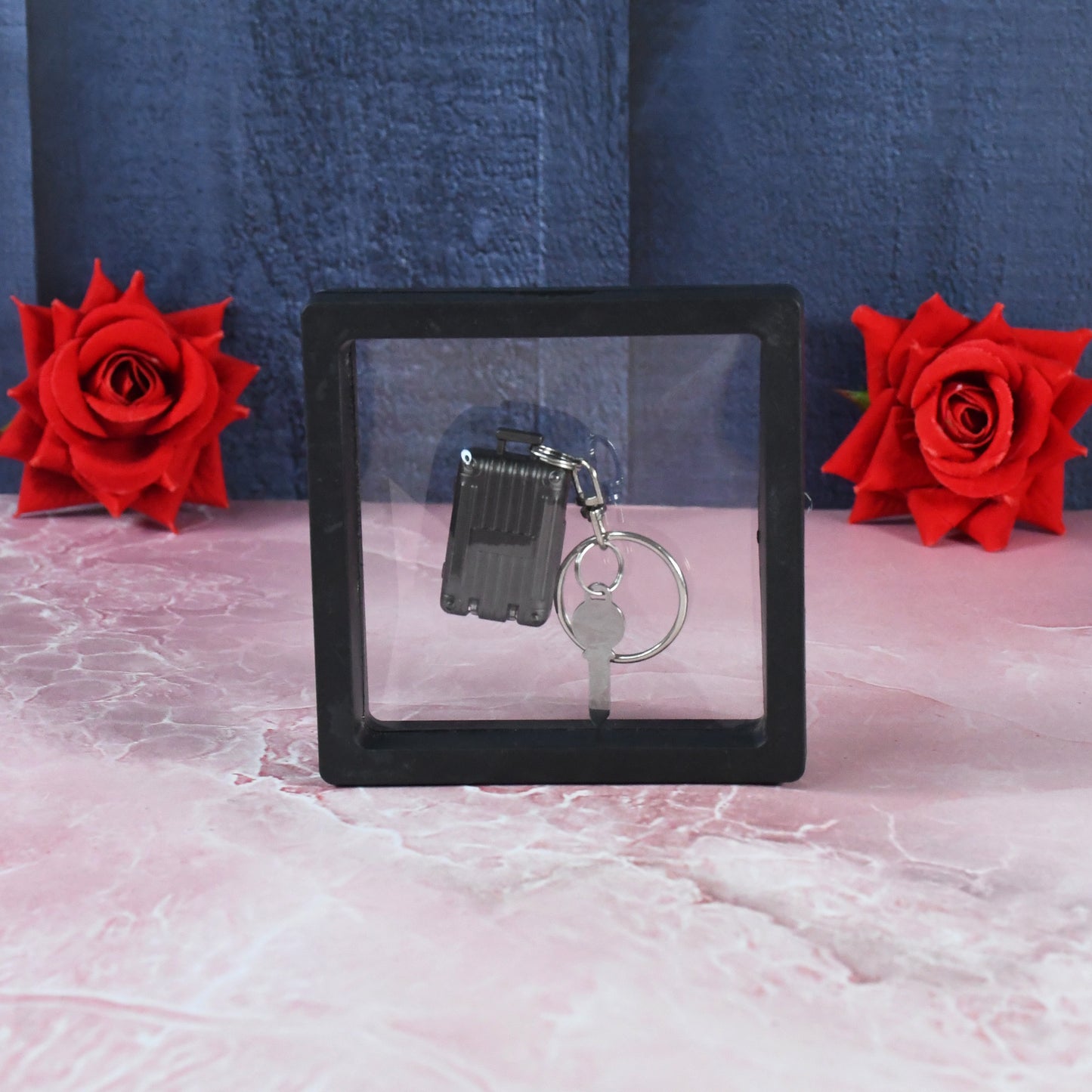 Wukusy suitcase-shaped nail clipper keychain with key in 3D floating frame display case, compact travel grooming accessory.