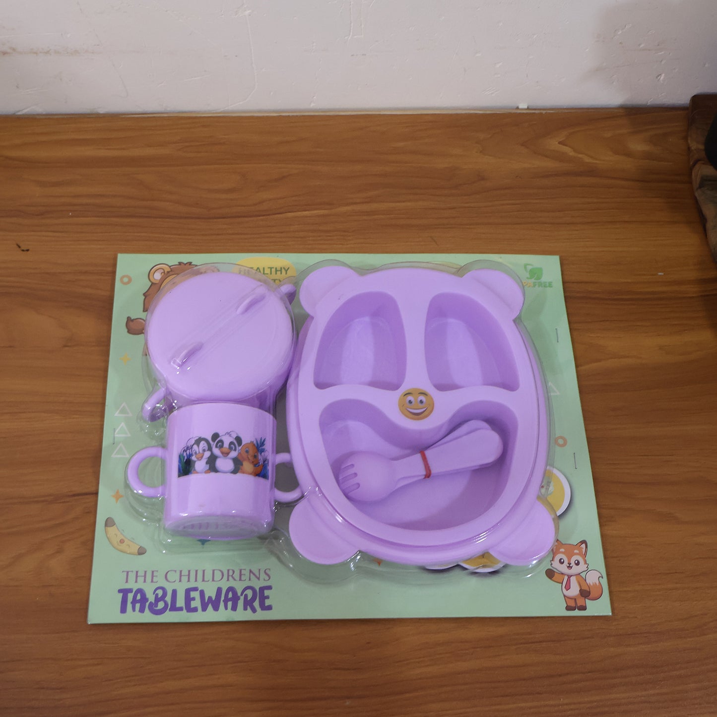Wukusy children's tableware dining set with colorful plates, bowls, and utensils for kids' meals in a home kitchen setting