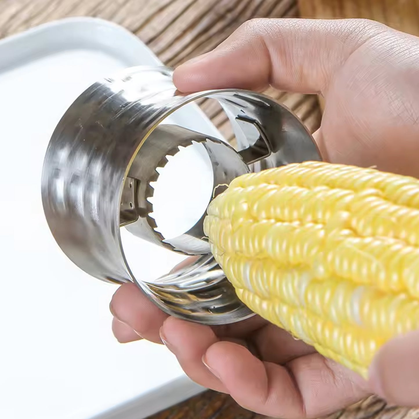 Wukusy stainless steel corn cutter and kernel remover tool for easy stripping of corn in a home kitchen setting.