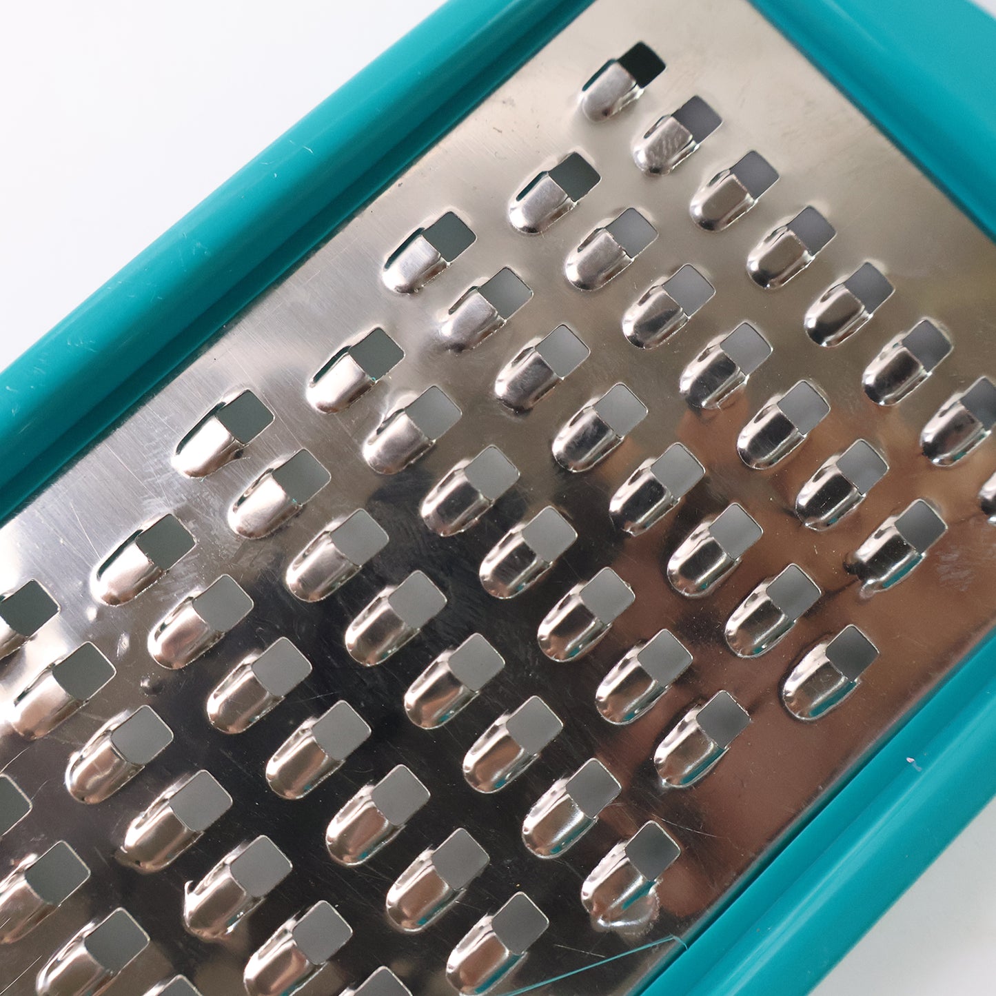 Wukusy multipurpose cheese and vegetable grater with a stainless steel surface and ergonomic handle for efficient grating.