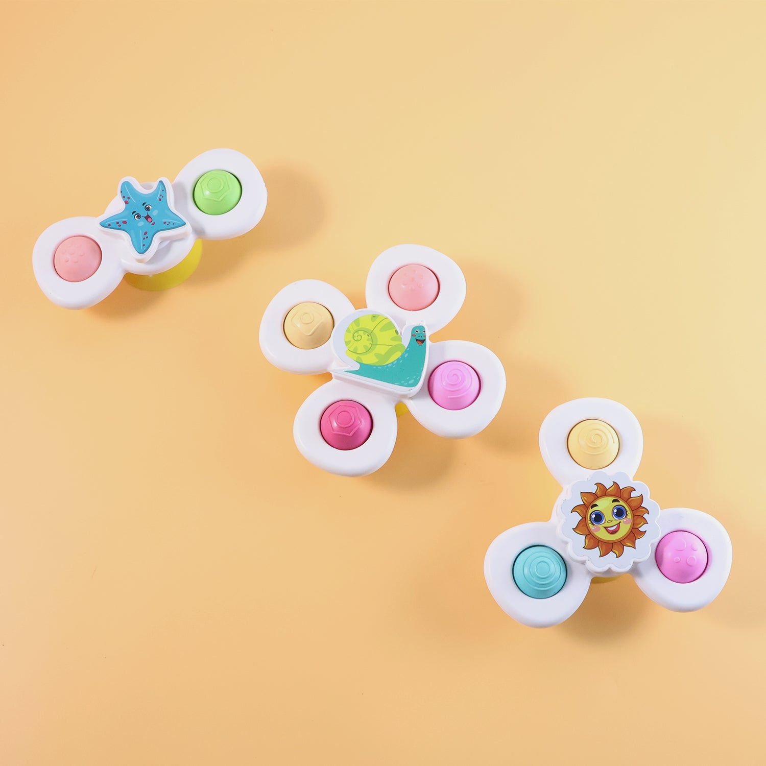 White baby spinner toy set by Wukusy with three sensory suction spin toys for infants and toddlers.