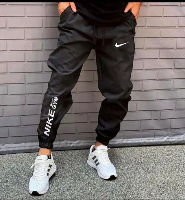 Black men's track pants by 13455, size 28, made from comfortable athletic fabric, shown flat with elastic waistband and side pockets.