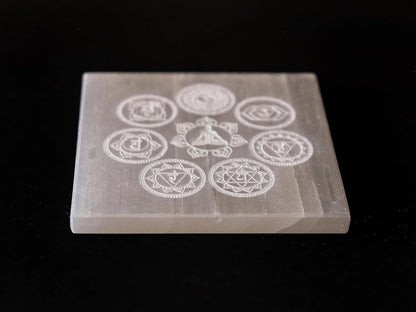 Natural selenite charging plate with seven chakra symbols, ideal for meditation, healing, and Vastu remedies in home and office.