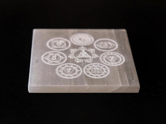 Natural selenite charging plate with seven chakra symbols, ideal for meditation, healing, and Vastu remedies in home and office.