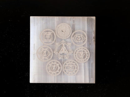 Natural selenite charging plate with seven chakra symbols, suitable for meditation, healing, and Vastu remedies in home or office.