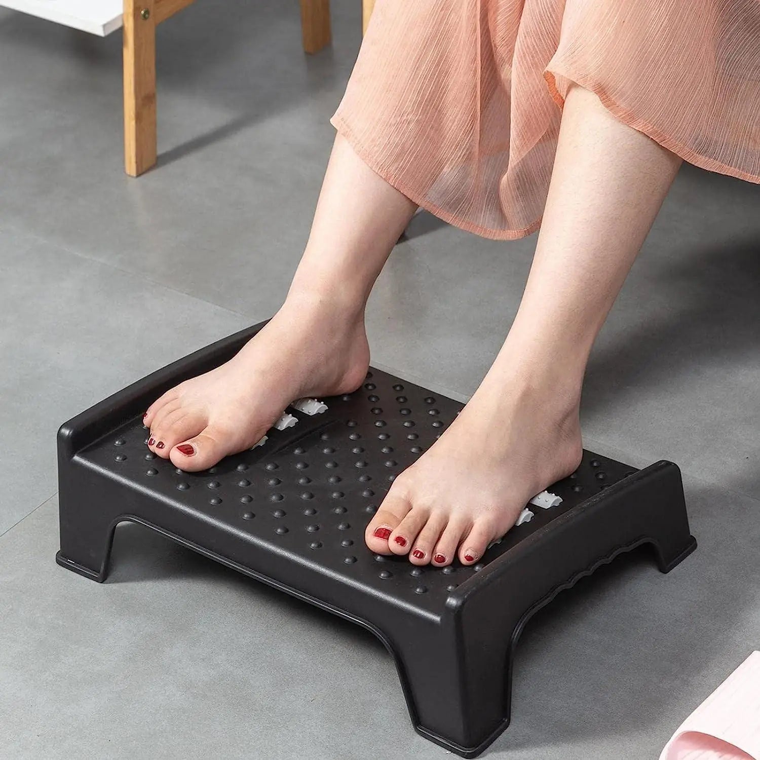 Foot rest for under desk with massage particles and roller, designed to improve comfort and support during work or relaxation.