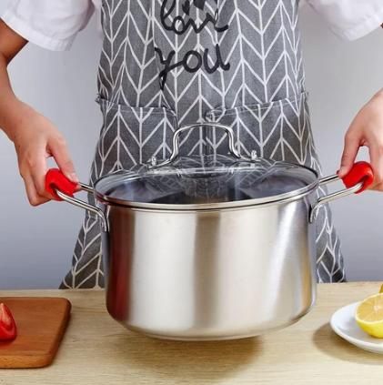 Silicone pot handle holder from 19378 kitchen tool set, shown gripping a pot handle for heat protection and safe handling.