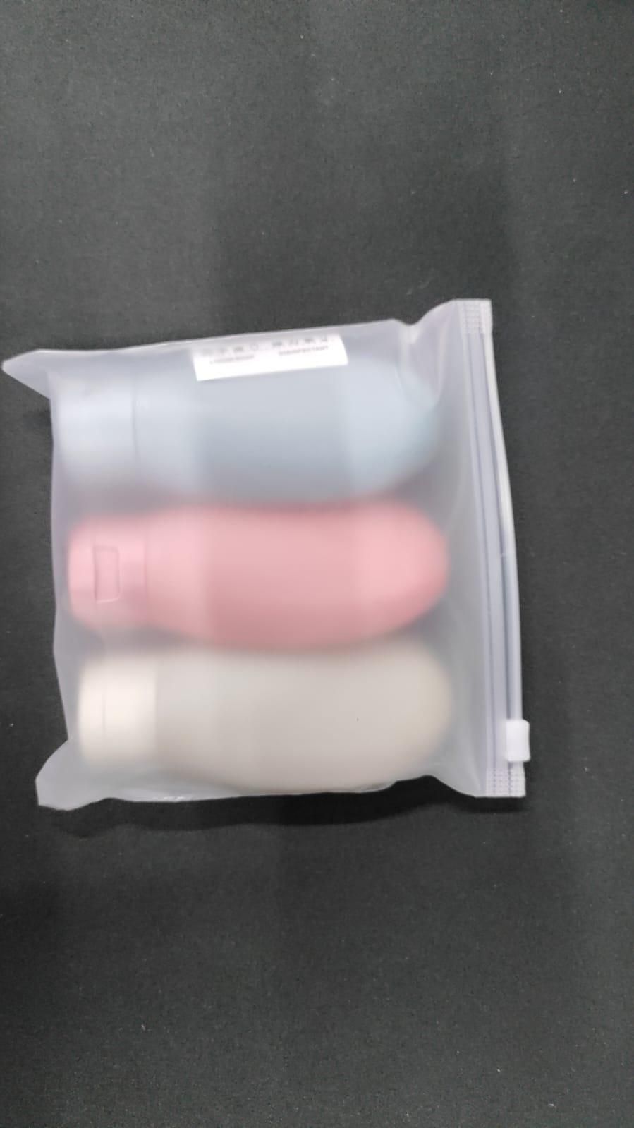 Set of three 60ml travel bottles for toiletries, clear plastic containers with black caps, ideal for kitchen or travel use.