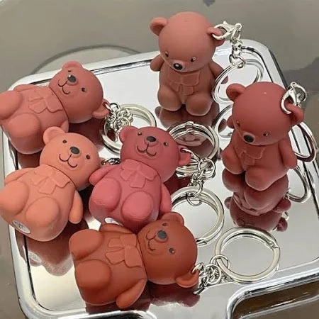 Six multicolored 19203 lipsticks with bear keychain, creamy matte texture, long-lasting formula, ideal for makeup and lip tint.