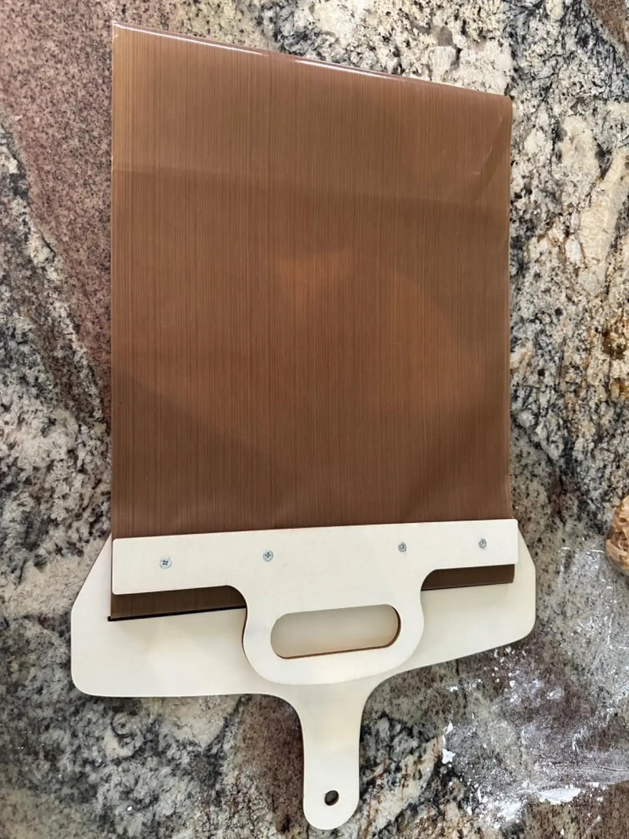 Wooden pizza paddle with smooth handle from kitchen tool set, ideal for transferring pizza crusts during baking.