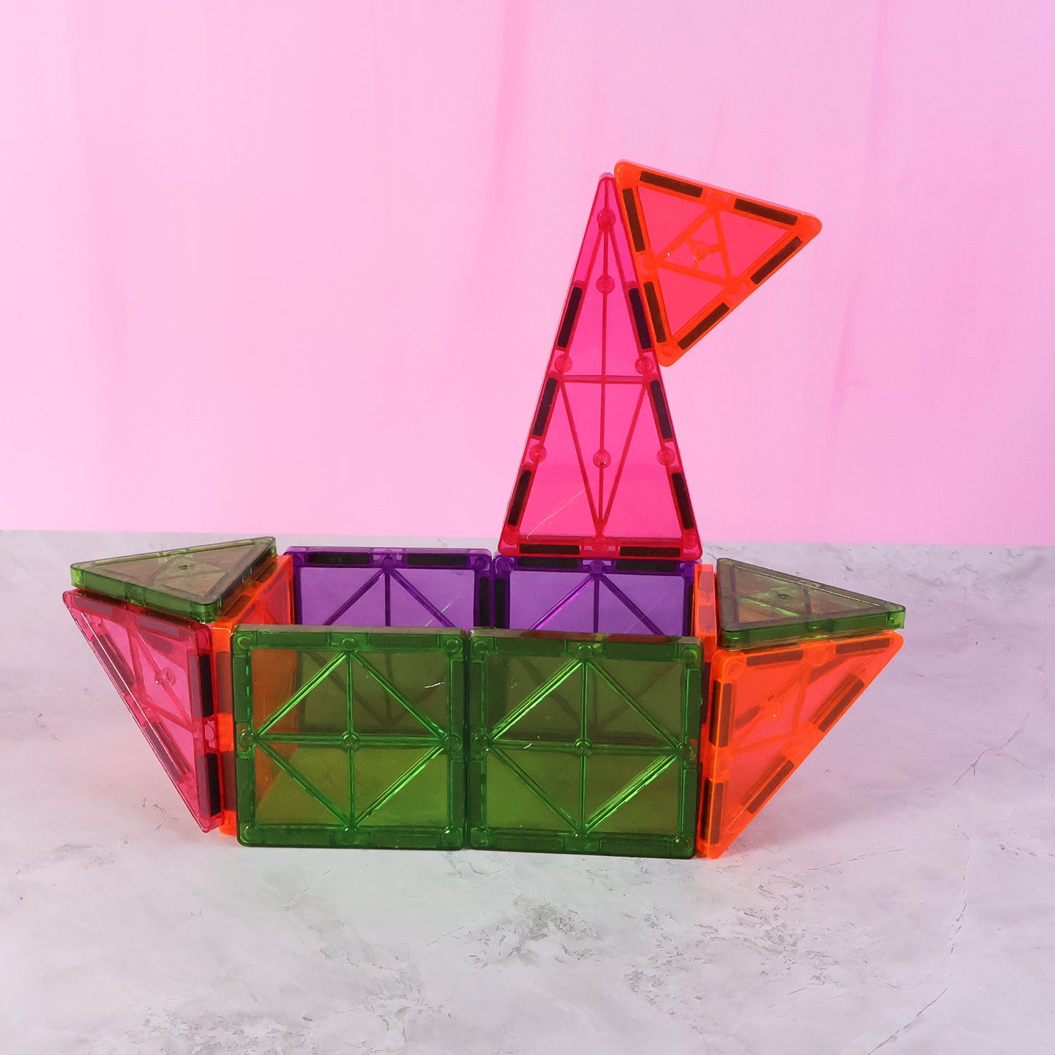 Colorful magnetic building tiles set by Wukusy with 32 pieces arranged in various geometric shapes on a surface.
