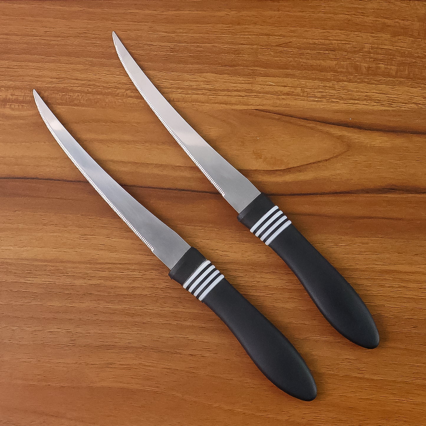 Wukusy premium curved serrated stainless steel kitchen knife set with two colorful knives on a wooden cutting board.